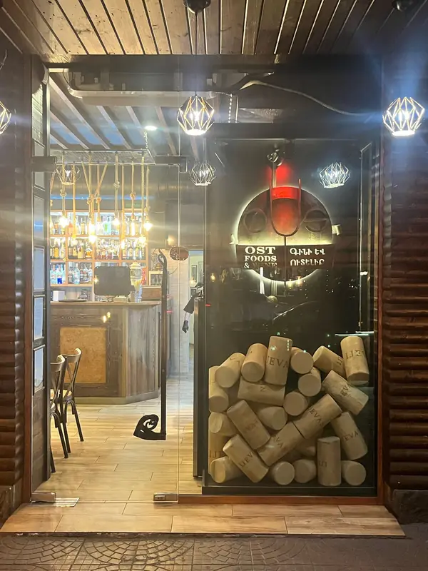 The glass entrance door stacked with wine corks under the lit sign