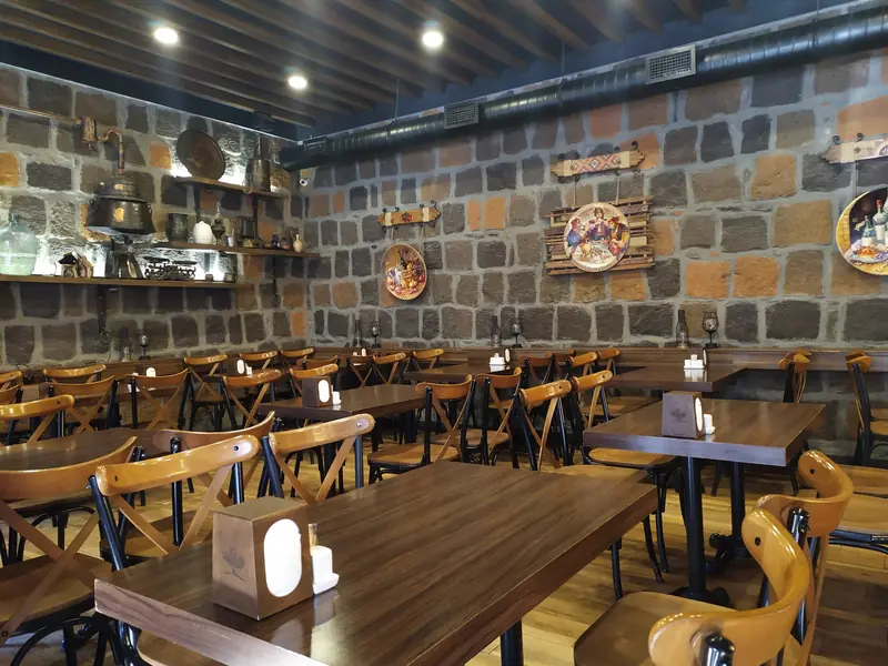 The hall: basalt stone wall with copper plates, walnut tables and bentwood chairs