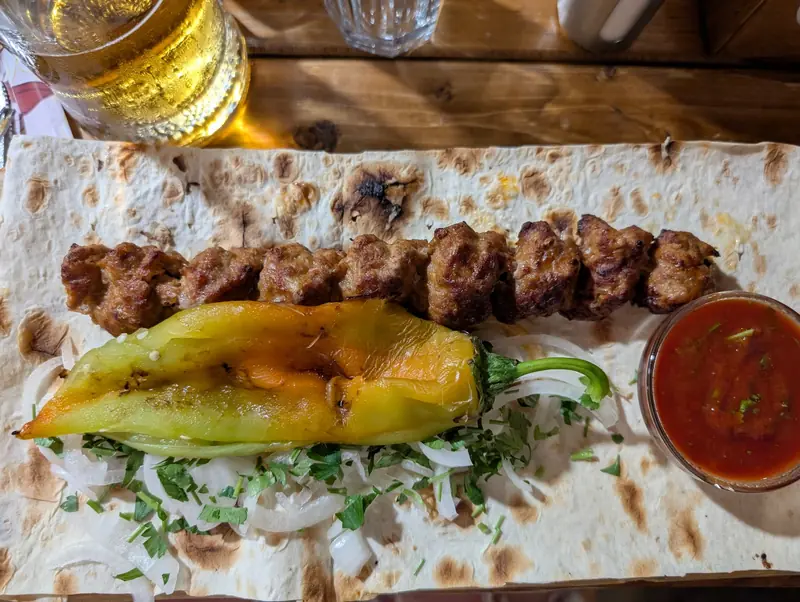 Kebab with a grilled green pepper on lavash